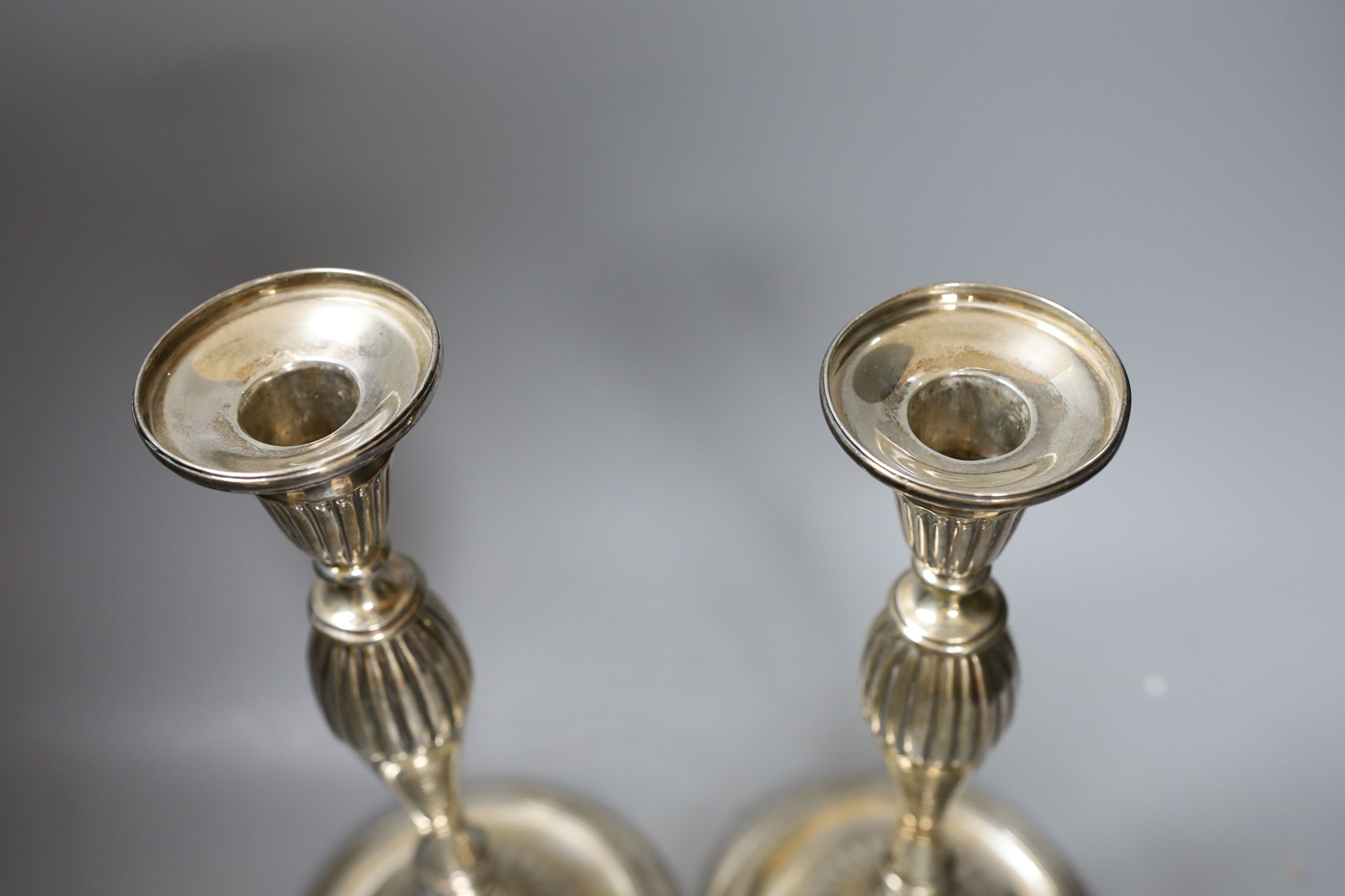 A pair of George III silver candlesticks, with waisted fluted stems, R.S. Sheffield, 1793 & 1796, 22.9cm, weighted (a.f.).